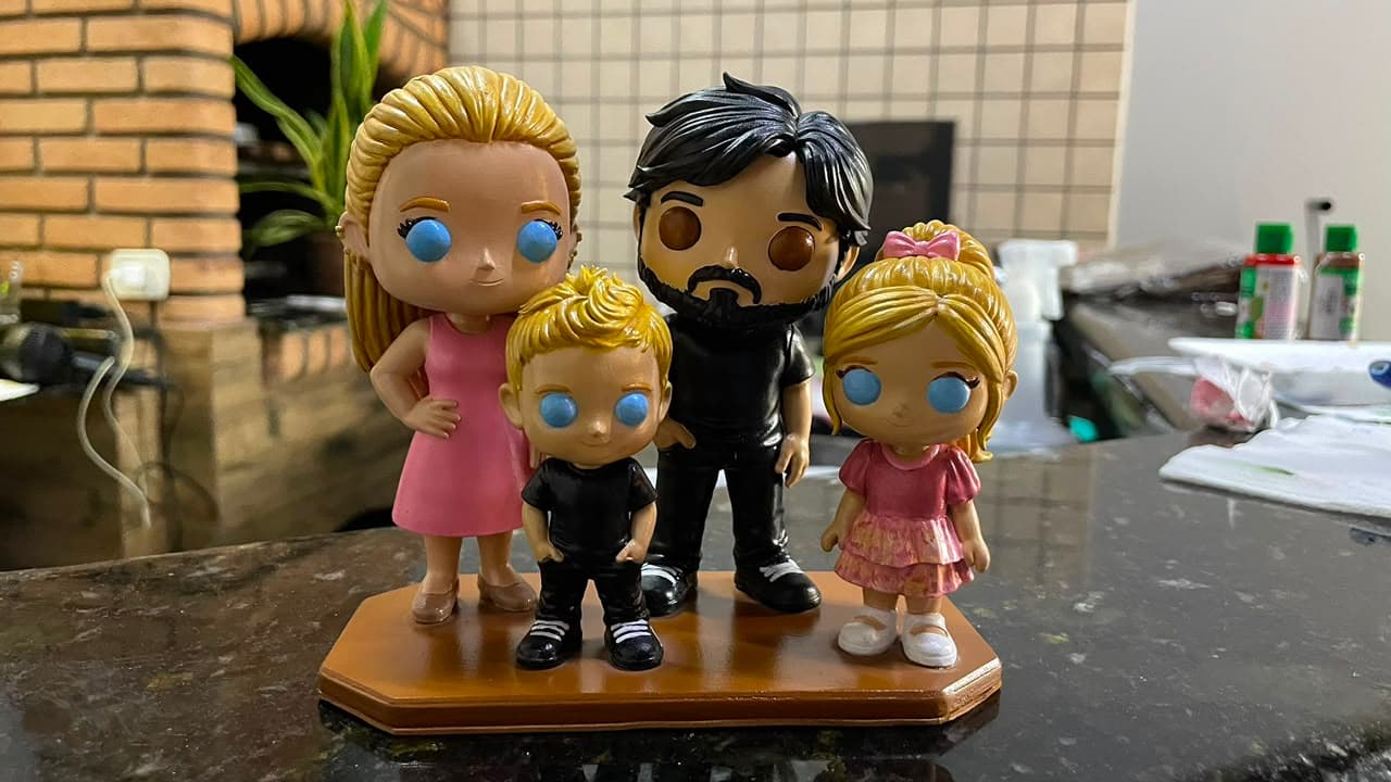Família de quatro pessoas em miniatura, pintada à mão, sobre uma base de madeira