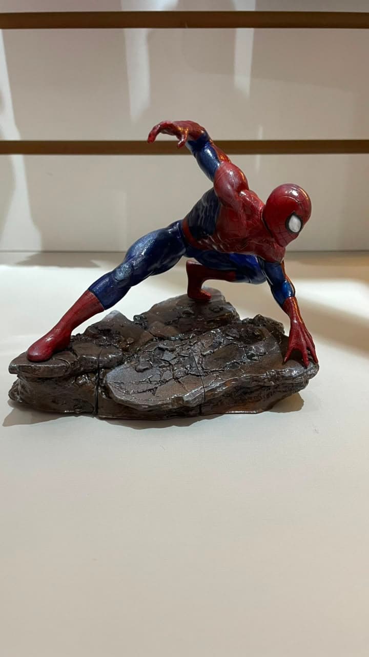 Miniatura do Homem-Aranha impressa em resina e pintada à mão, em pose de ação