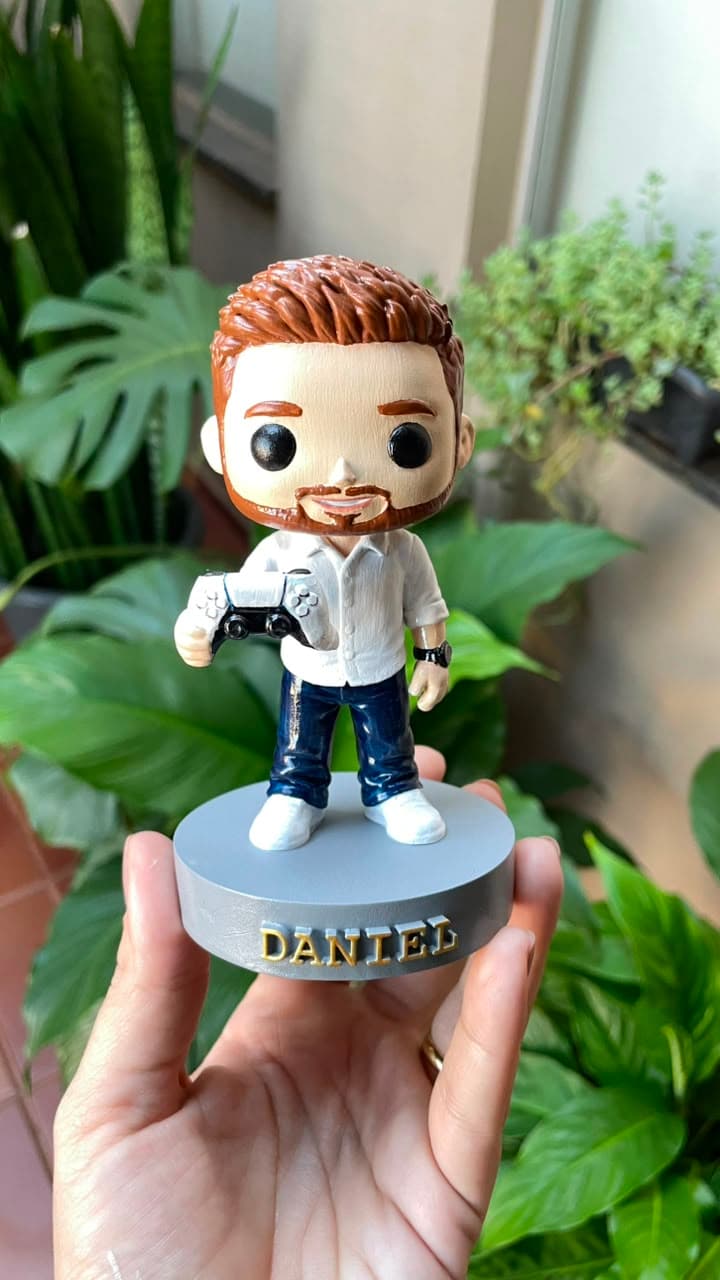 Miniatura personalizada segurada na mão, com o nome do dono na base